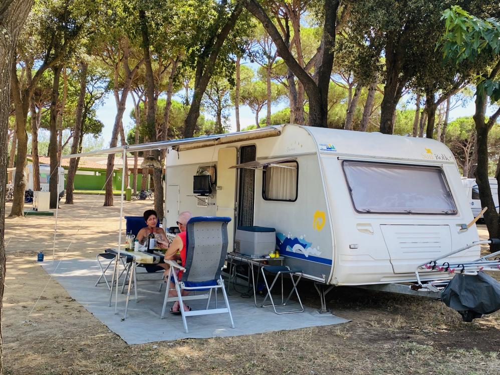 Couple in front of a caravan on the beach